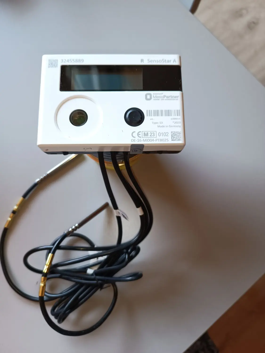 Fair Therm GmbH - Rechtskonforme Abrechnung und Analyse - Ein weißes, rechteckiges elektronisches Gerät mit der Aufschrift „Cengelmann“ und „Sontex“, wahrscheinlich ein Wärme- oder Wasserzähler, mit digitaler Anzeige und unten angeschlossenen Drähten.